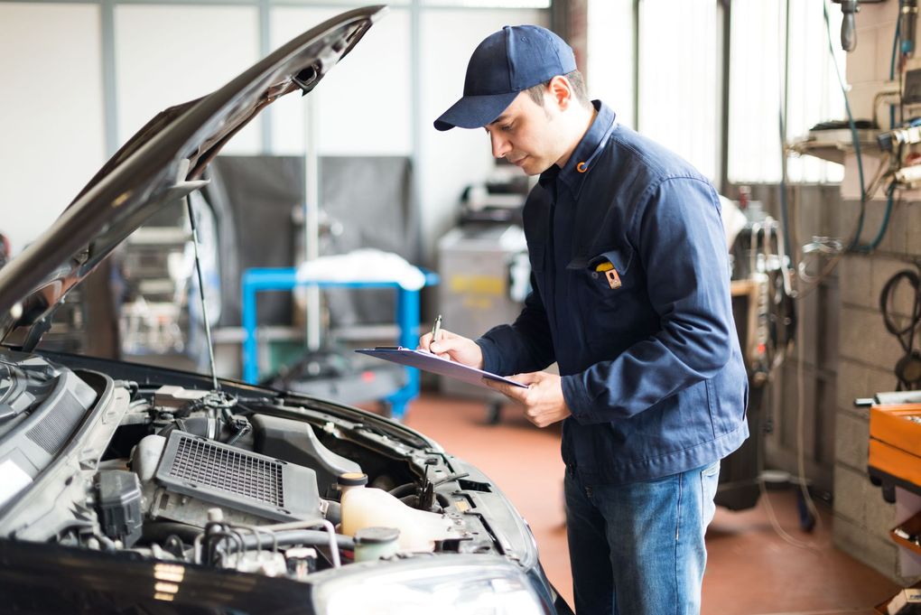 Mechanic inspecting a car engine in an auto repair shop with the hood open