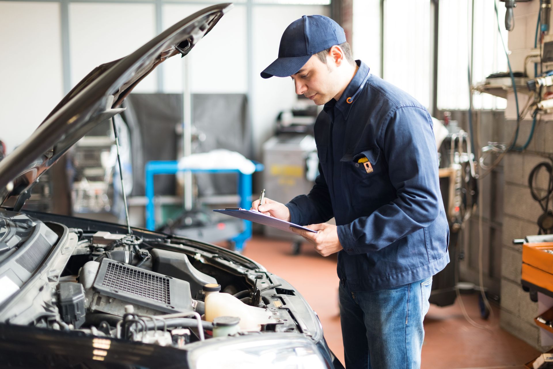 Mechanic inspecting a car engine in an auto repair shop with the hood open