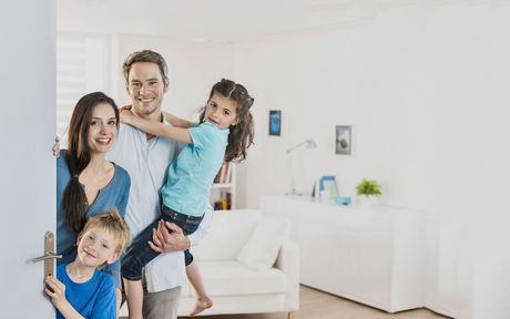 A family is posing for a picture in their new home.