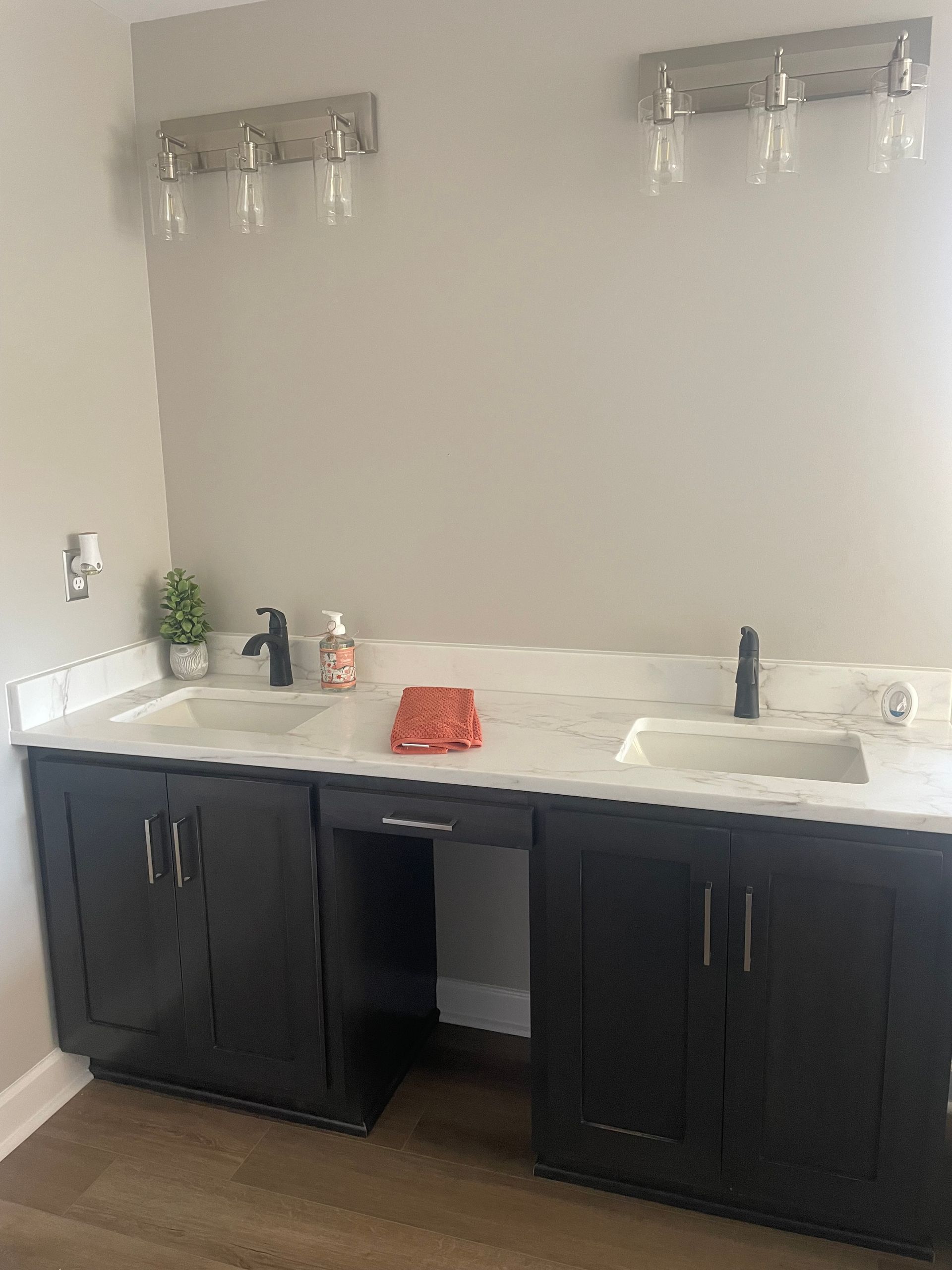 A bathroom with two sinks , a tub , and a large mirror.