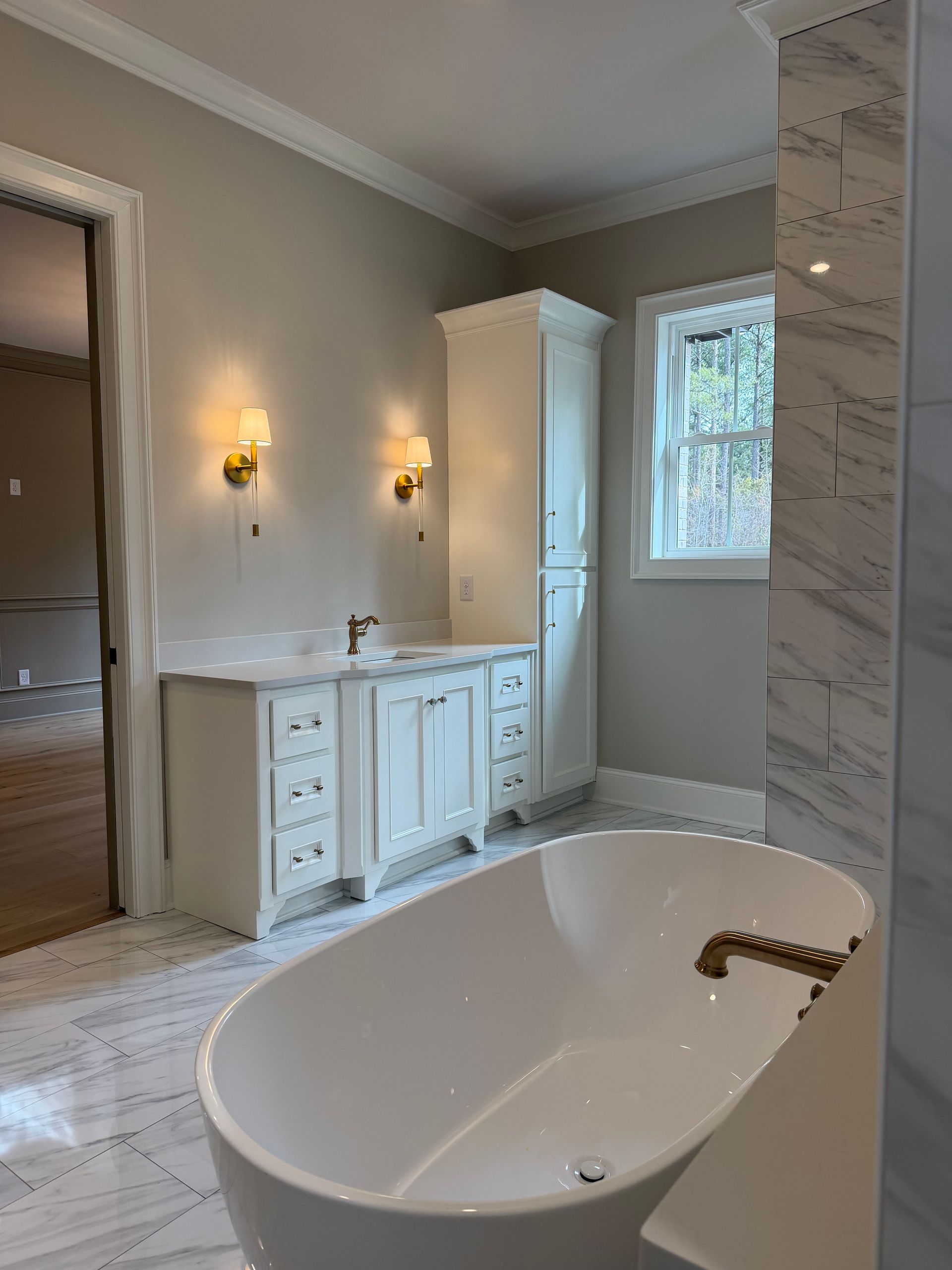 A bathroom with two sinks , a tub , and a large mirror.