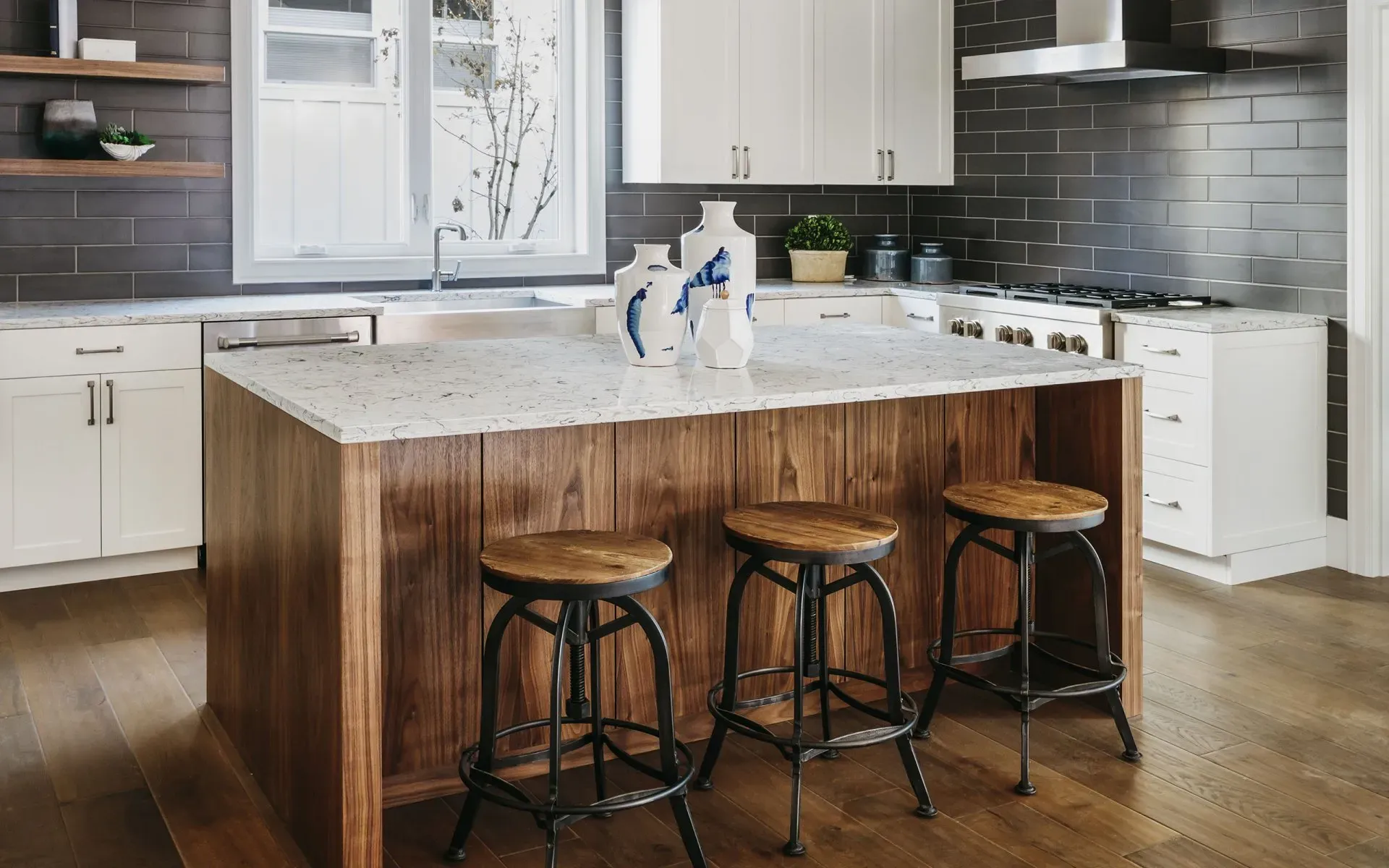 A kitchen with a large island and three stools.