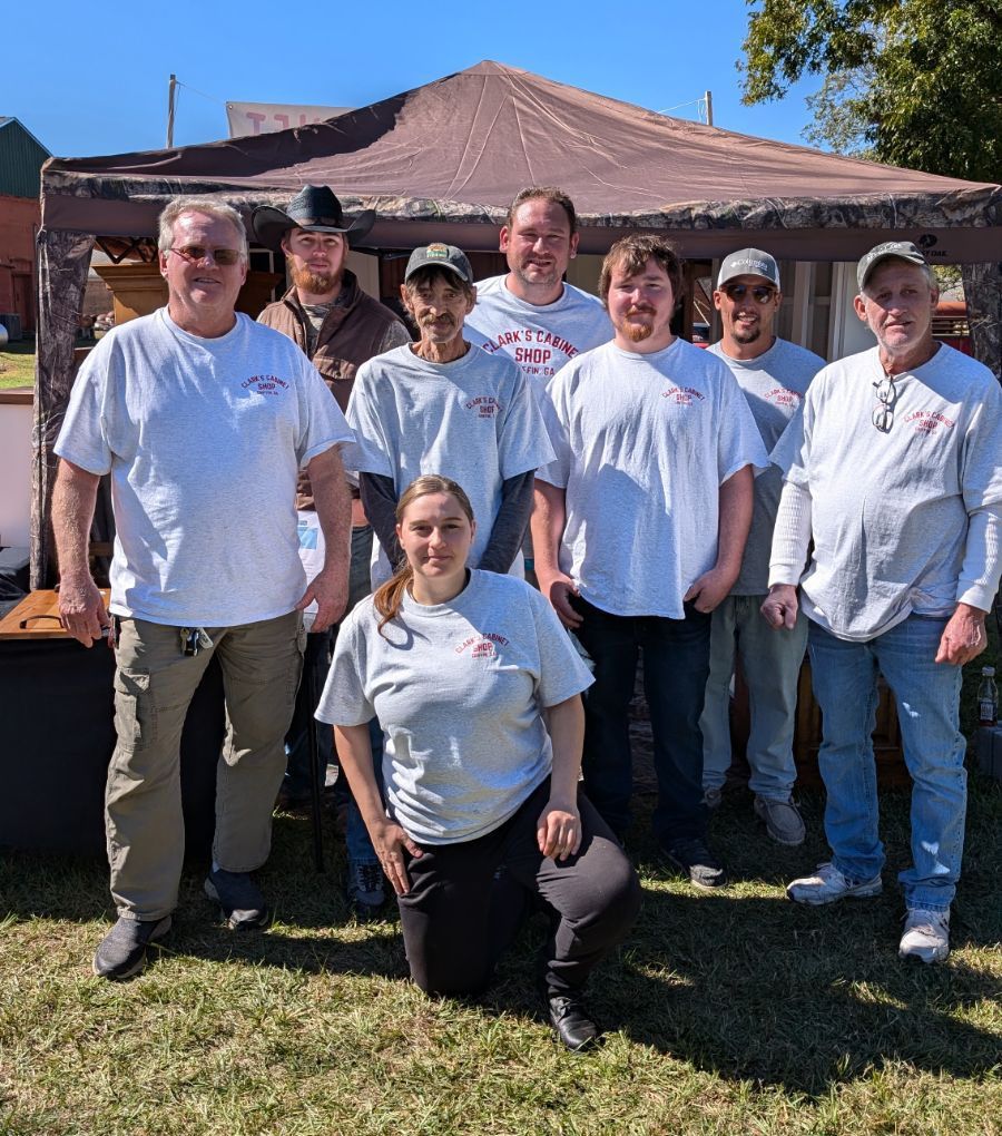 A group of people are posing for a picture in front of a tent.