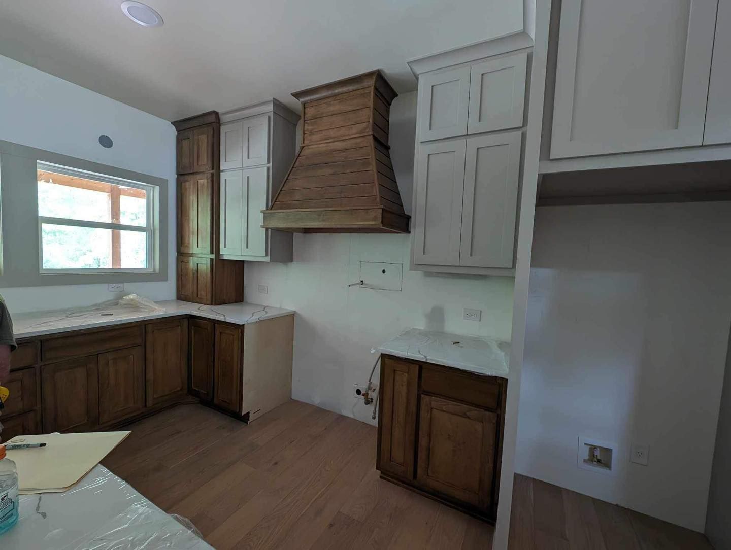 A kitchen with wooden cabinets and white countertops is being remodeled.