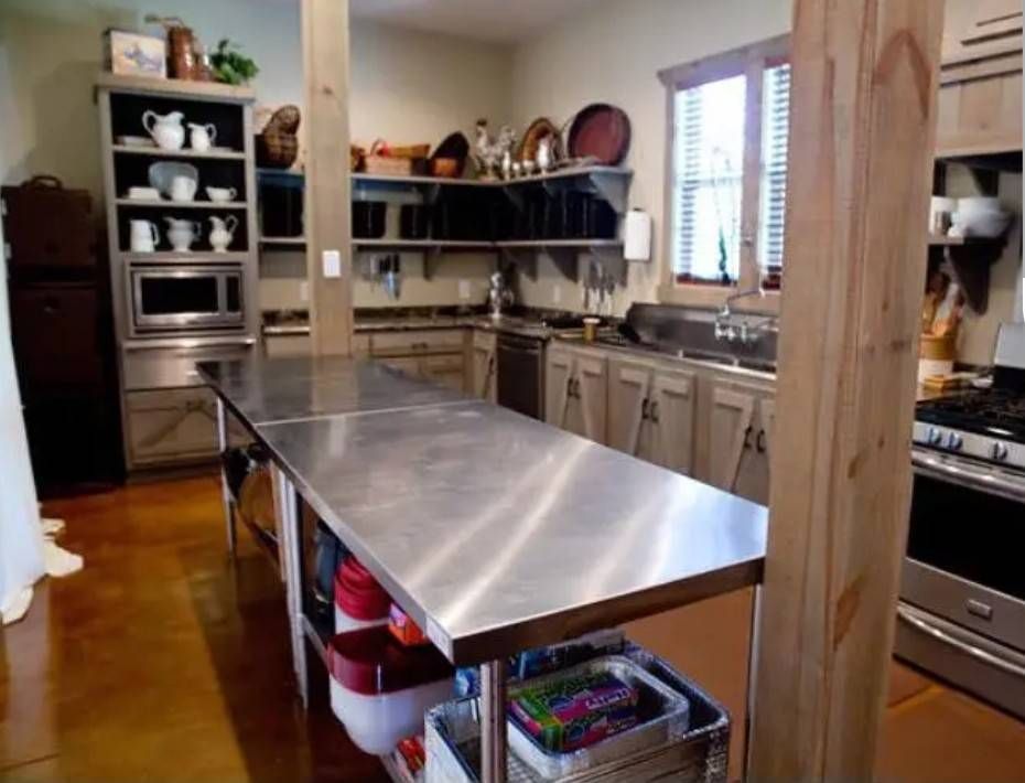 A kitchen with a long stainless steel table