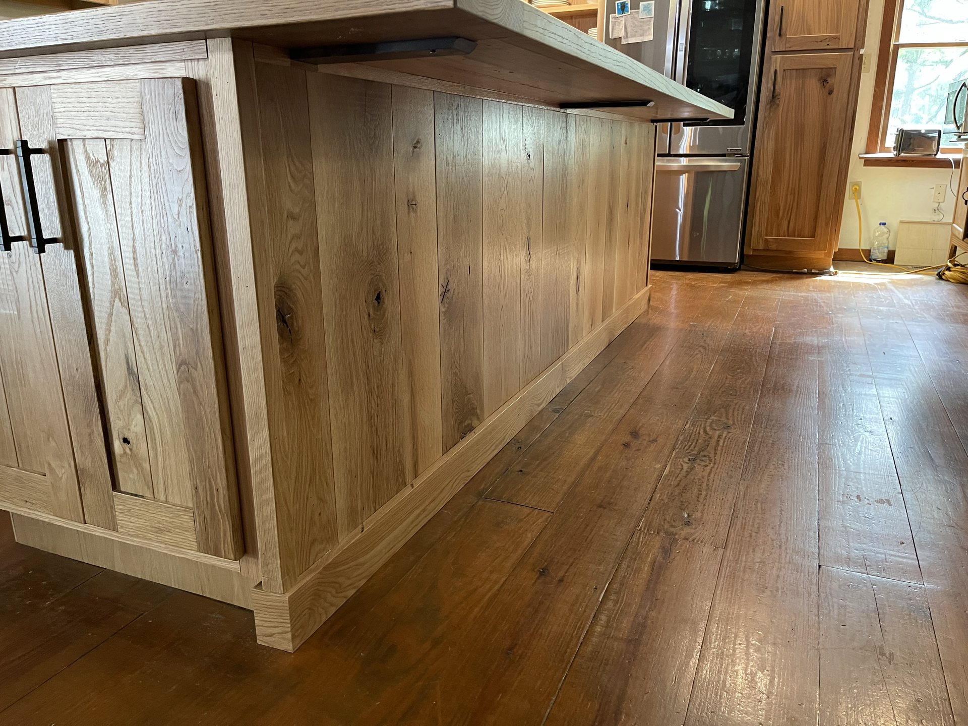 A kitchen with wooden cabinets and a wooden island
