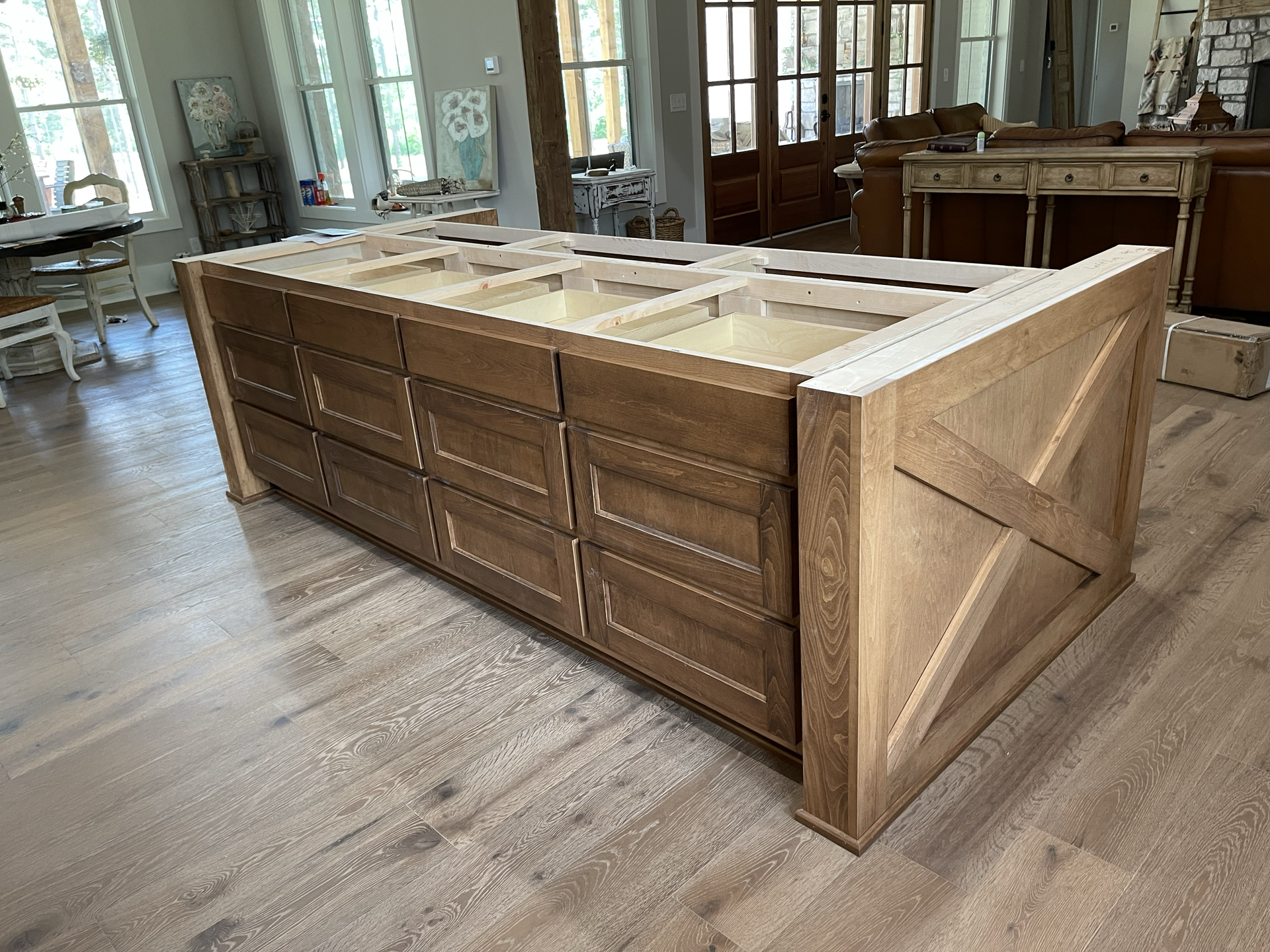 A large wooden island with drawers and sinks in a kitchen