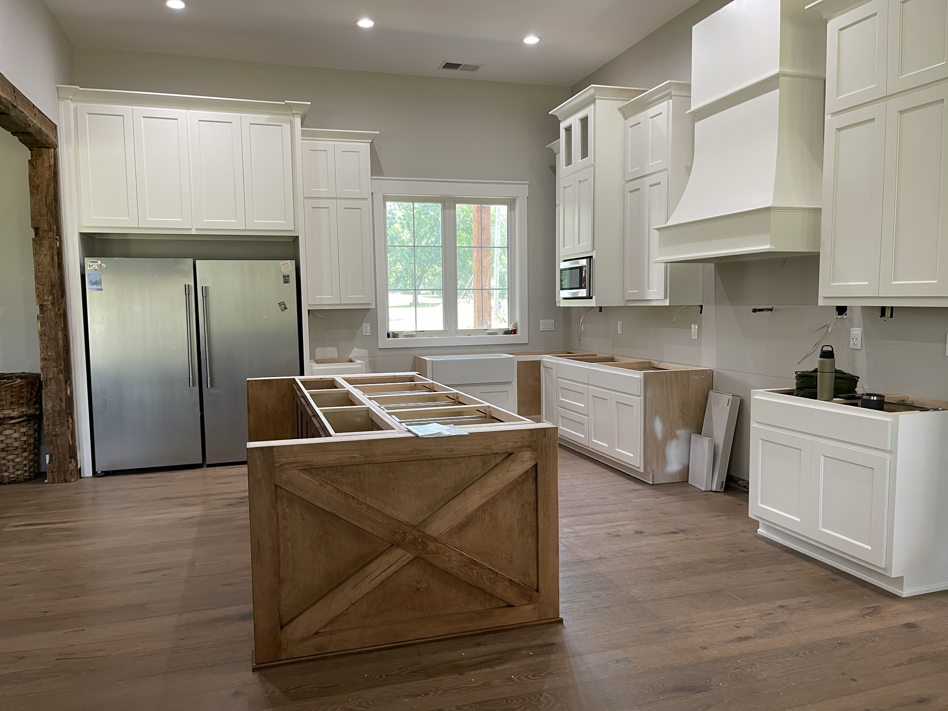 A kitchen with white cabinets and a stainless steel refrigerator