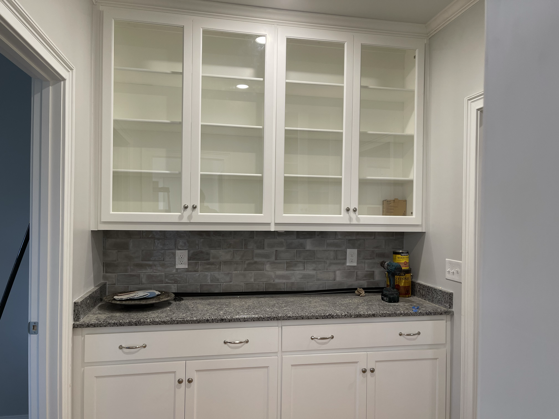 A kitchen with white cabinets and granite counter tops