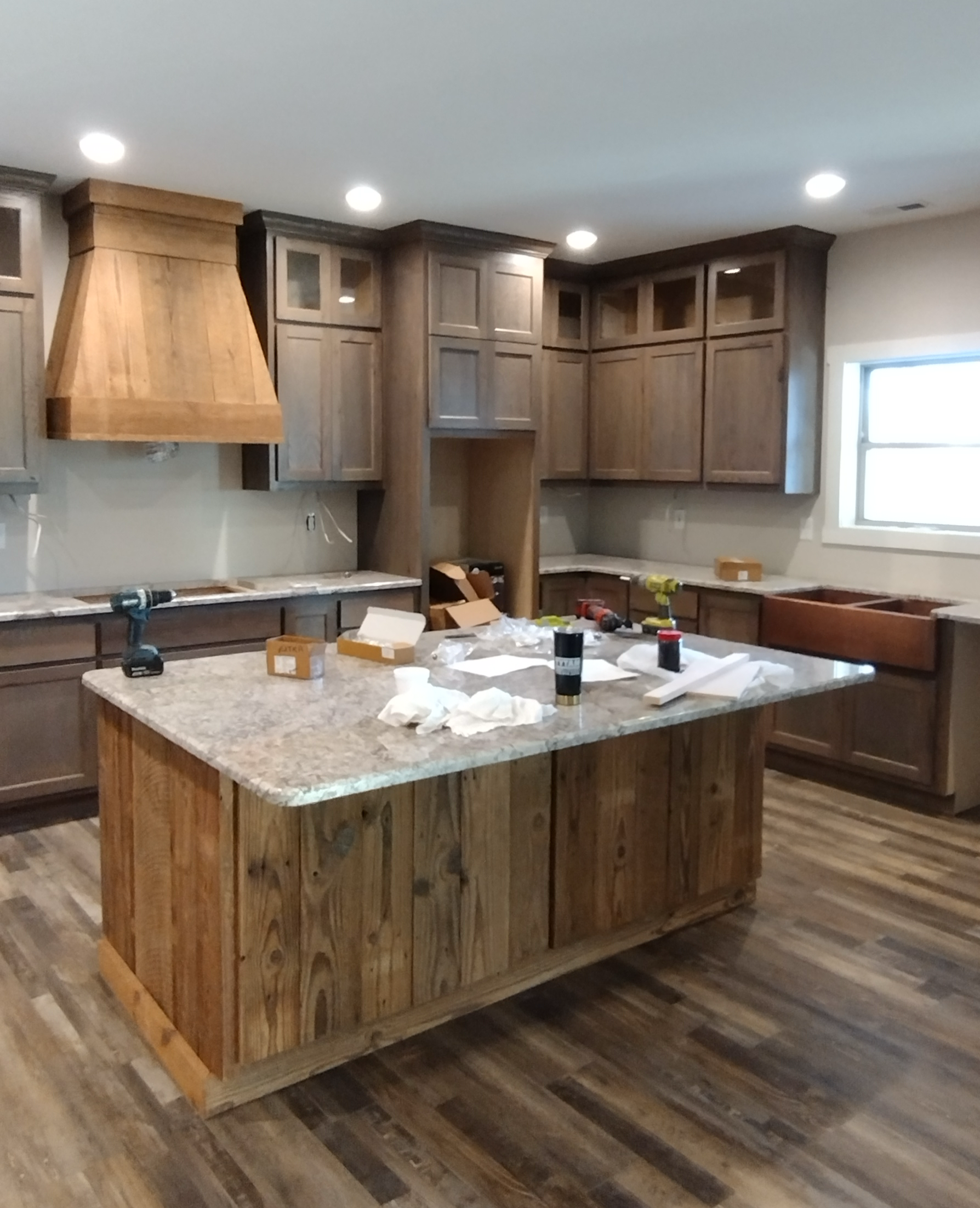 A kitchen with wooden cabinets and a large island in the middle