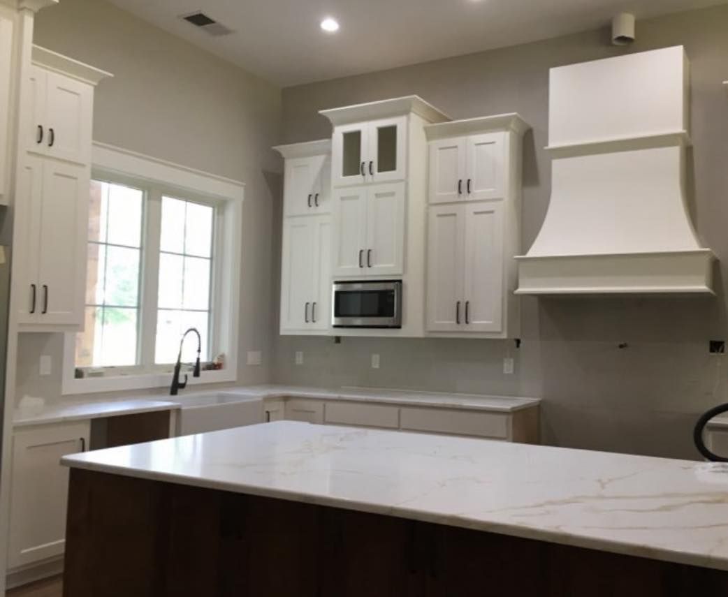 A kitchen with white cabinets and a large island