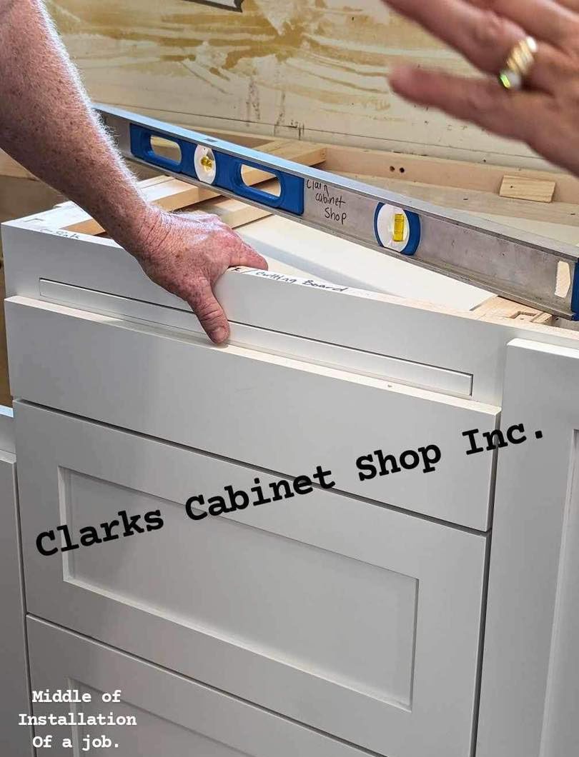 A person is using a level to check the level of a cabinet
