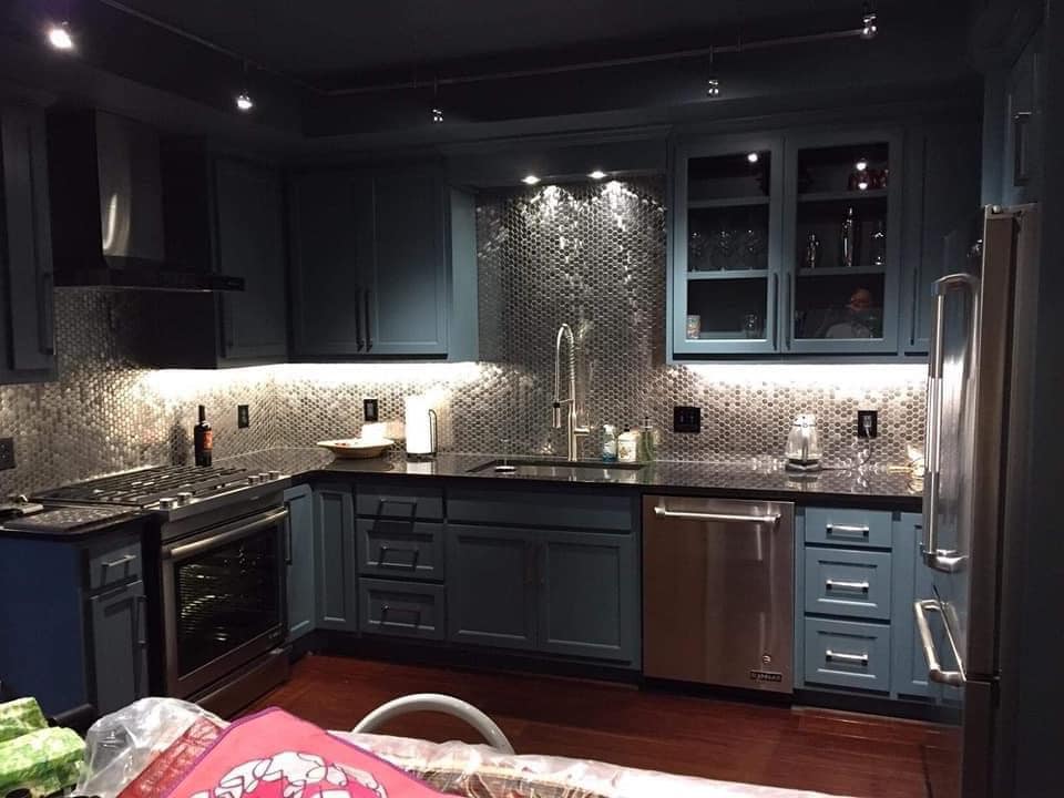 A kitchen with blue cabinets and stainless steel appliances