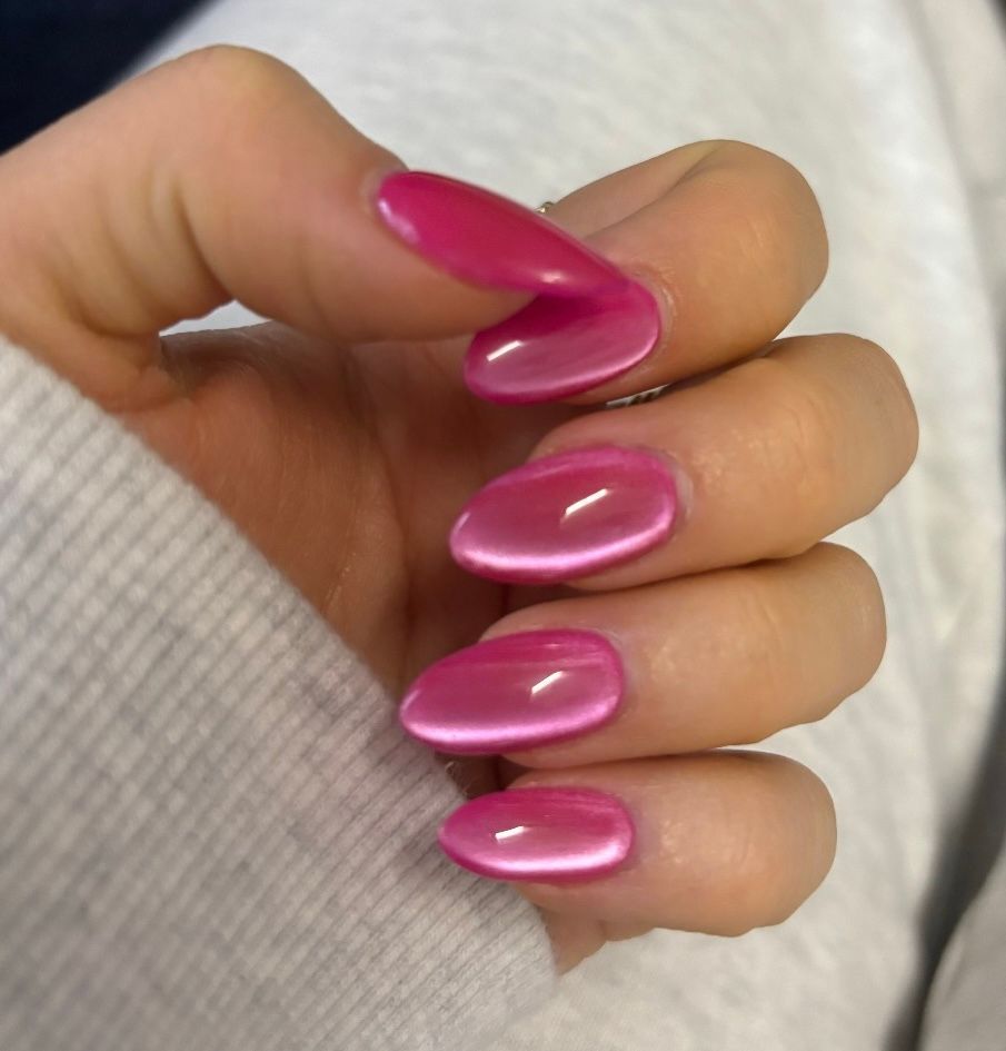 Hand with glossy pink acrylic nails resting on a light sweater sleeve