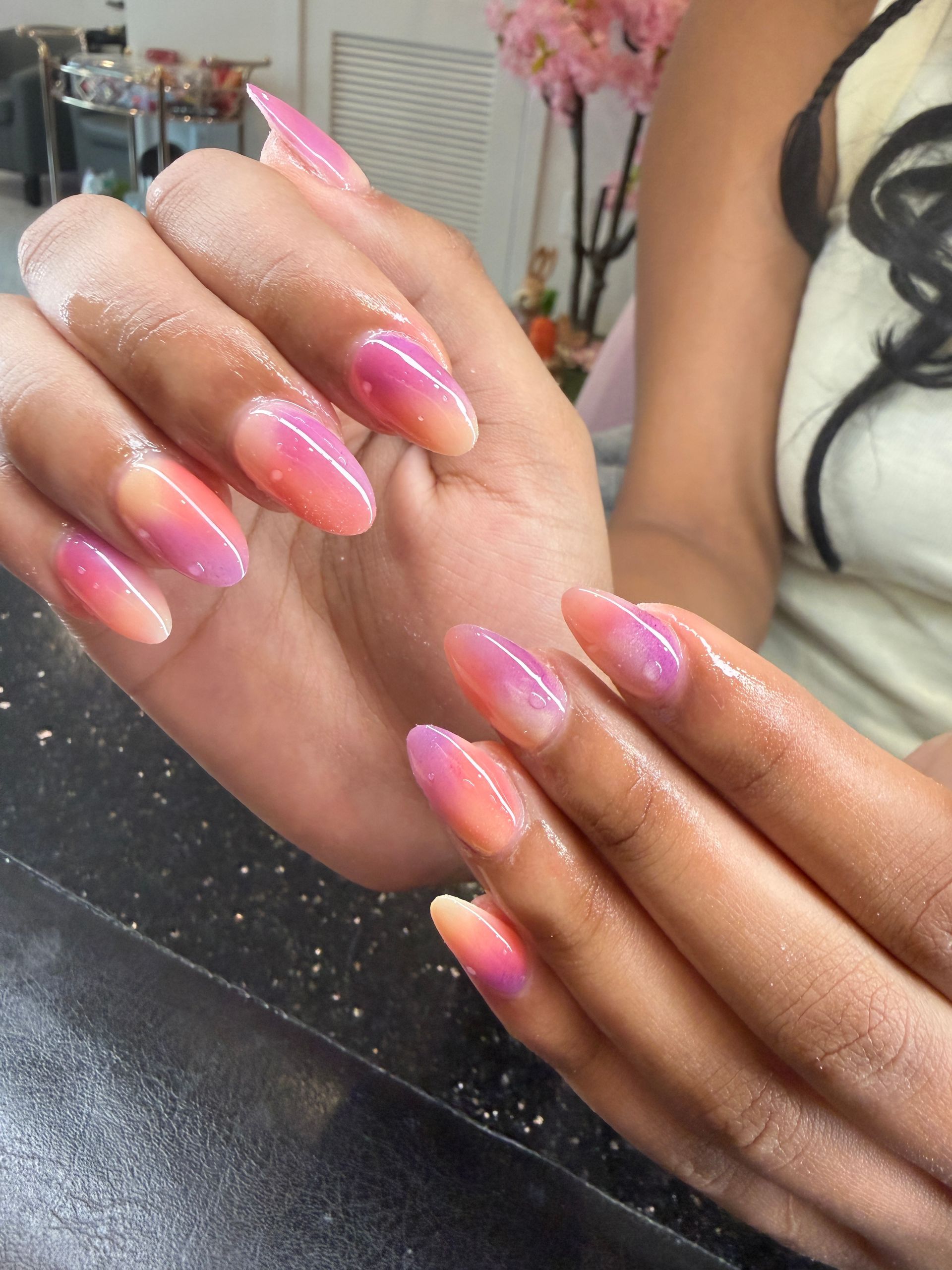 Pink acrylic nails on hands.