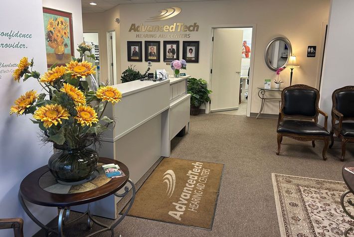 A waiting room with a table and chairs and a rug that says adrienne medical