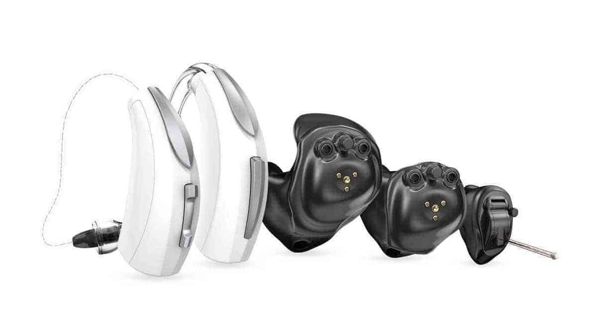 A group of hearing aids are sitting next to each other on a white background.