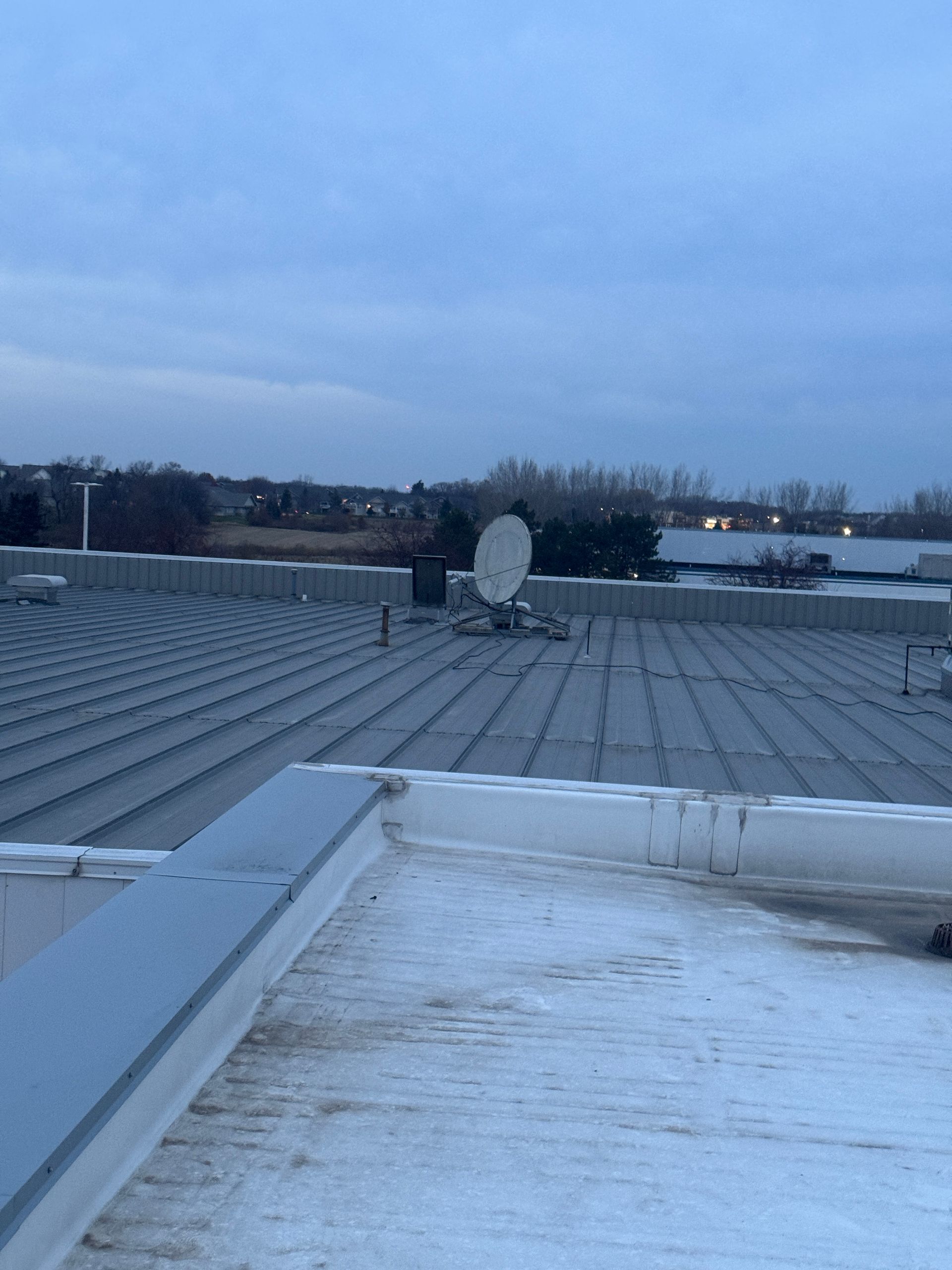 Rooftop with a satellite dish under a cloudy sky.