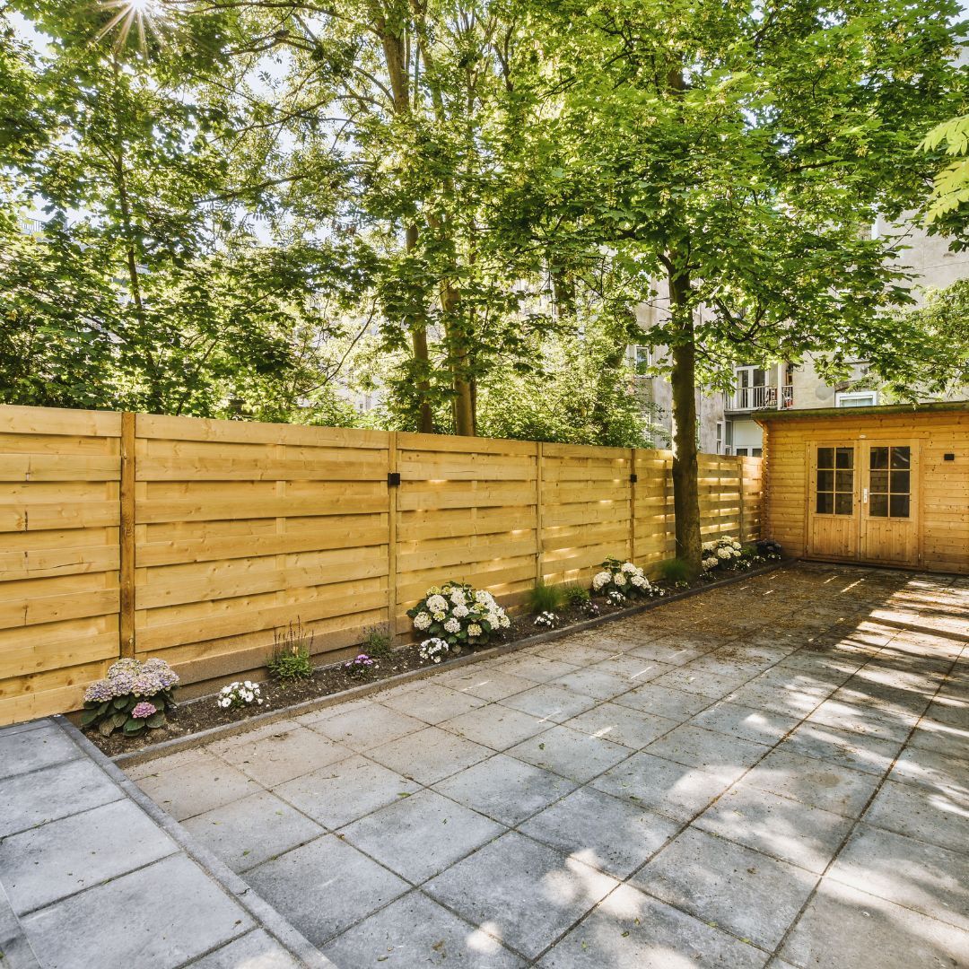 A backyard with a wooden fence and a shed.