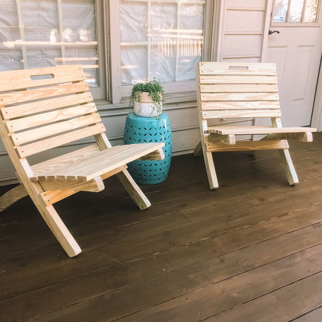 Two wooden chairs are sitting on a porch next to a blue stool.