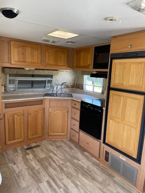A kitchen with wooden cabinets and a refrigerator