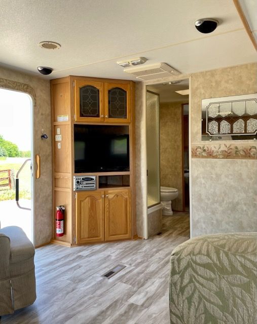 A living room in a camper with a flat screen tv