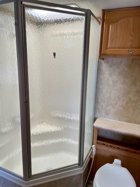 A bathroom with a toilet and a shower stall