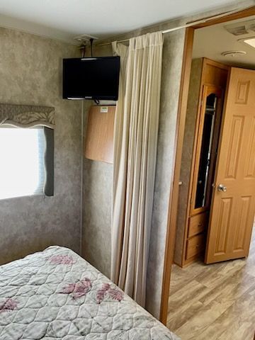 A bedroom with a bed , television , and door.