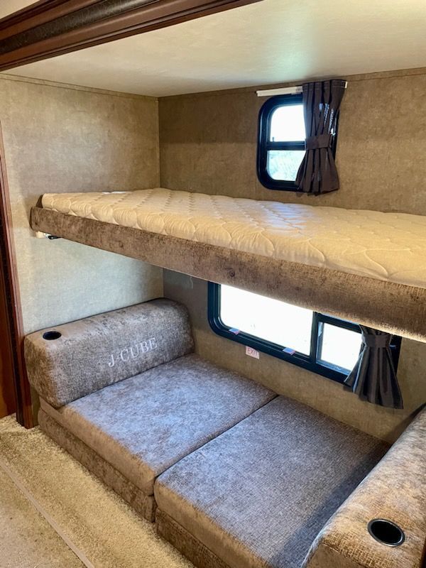An RV with two bunk beds and a couch.