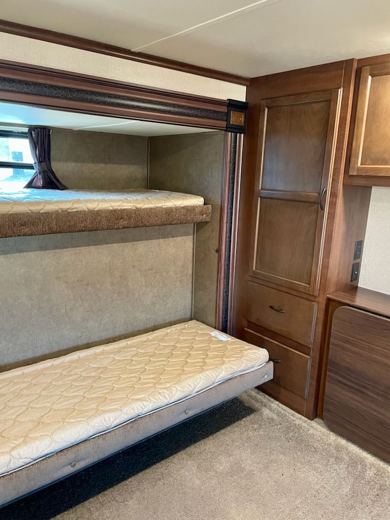 An RV with two bunk beds and a couch.