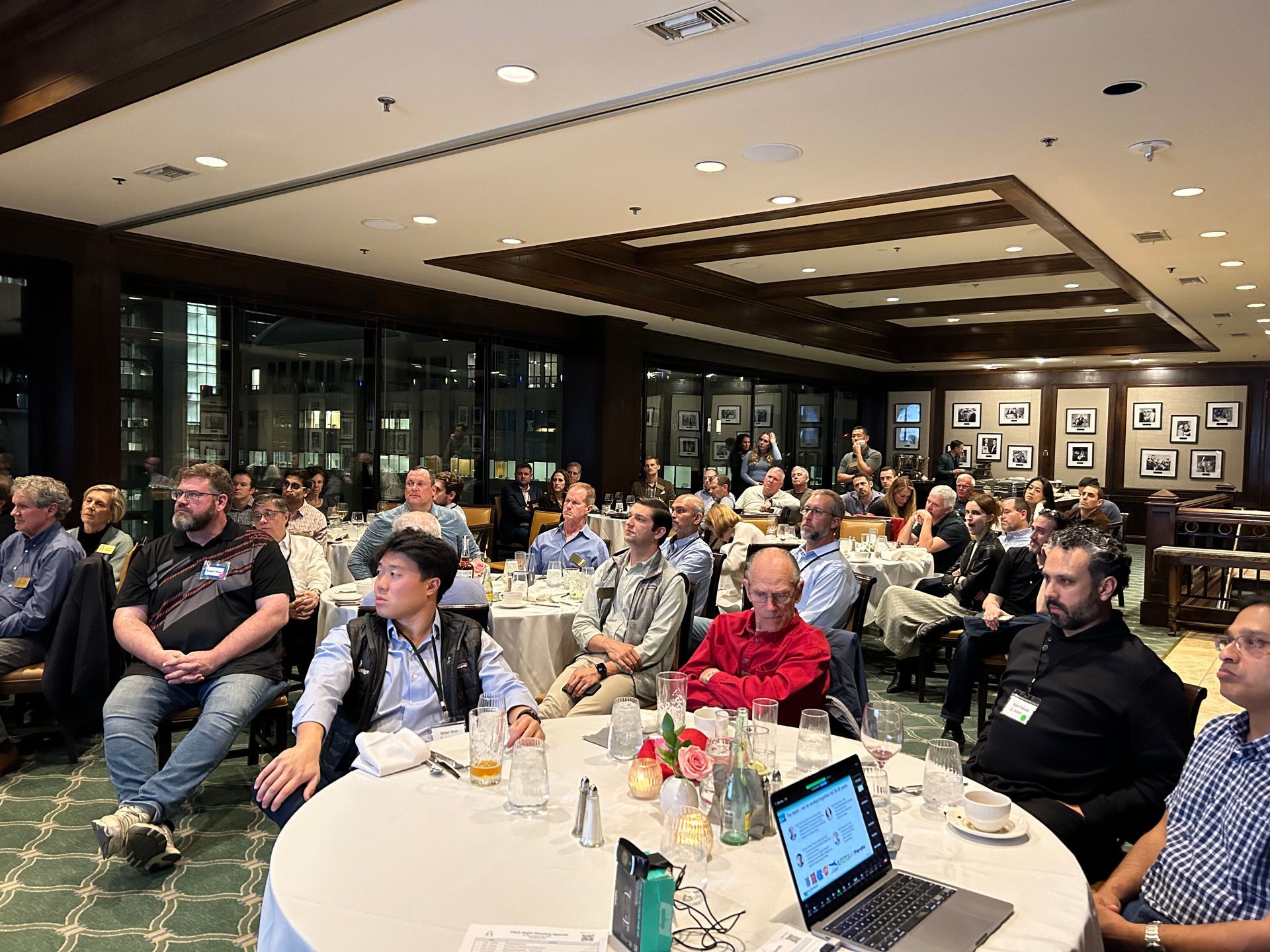A group of people are sitting at tables in a large room.