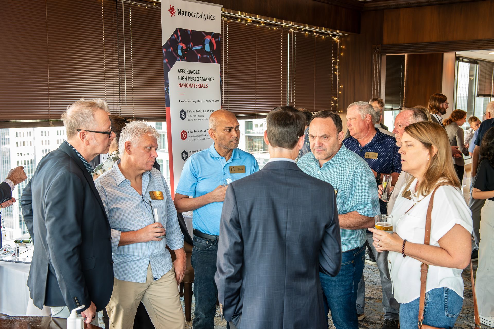 A group of people are standing in a room talking to each other.