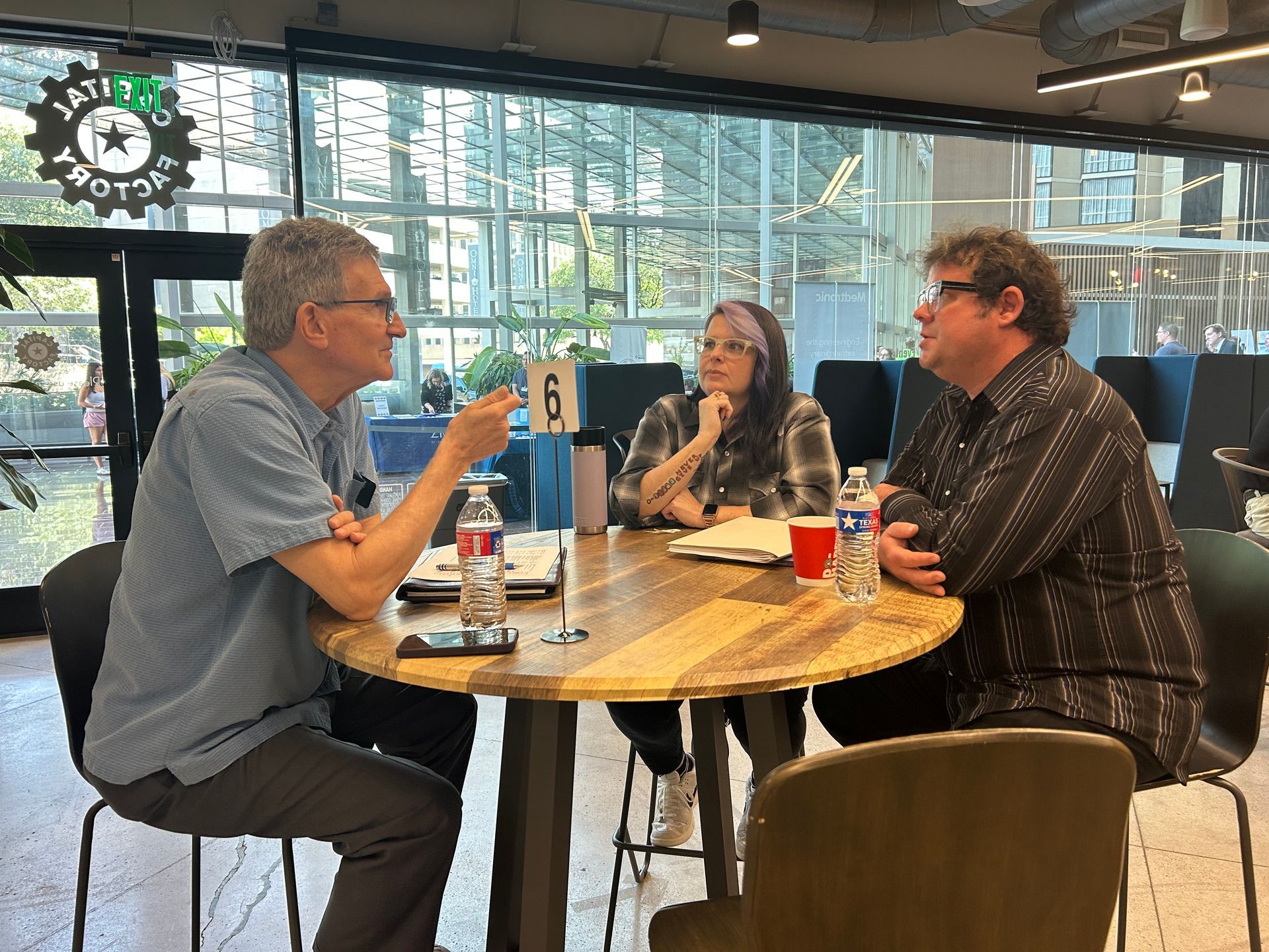 A group of people are sitting around a table having a conversation.