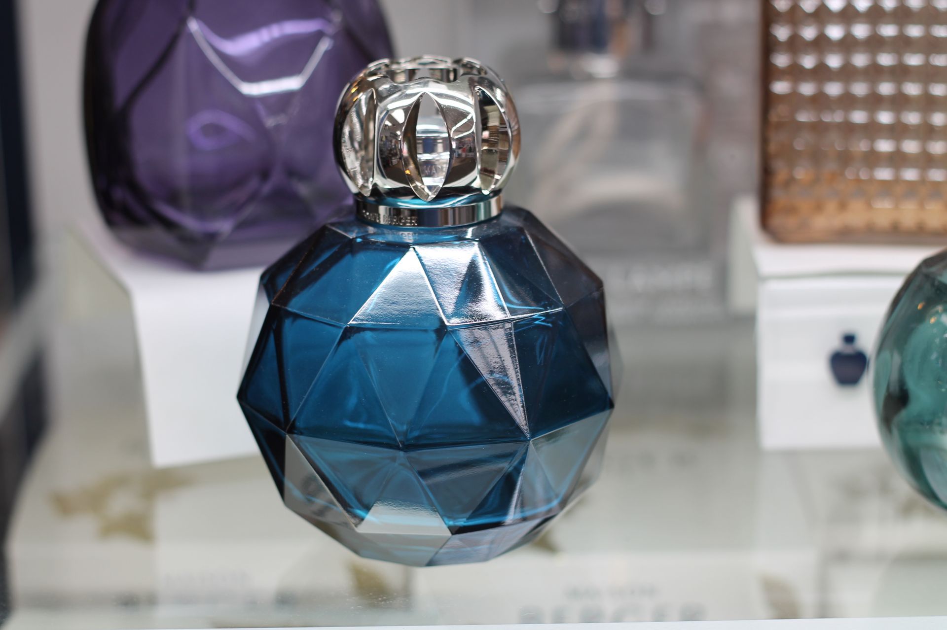 Blue and silver faceted perfume bottle on display.