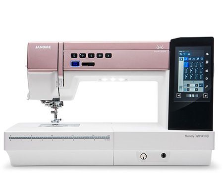 A light pink and white Janome Memory Craft sewing machine with a touchscreen.