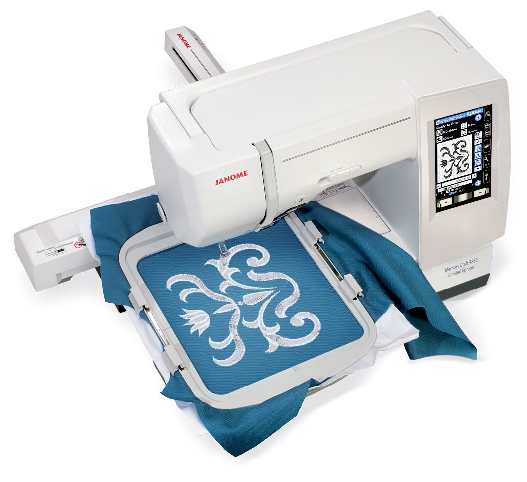 White embroidery machine stitching a blue fabric with a floral design.