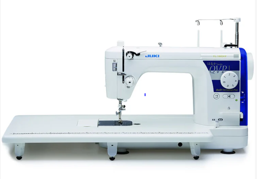 White and blue Juki industrial overlock sewing machine on a white table.