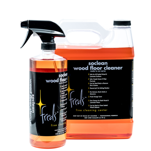 Two bottles of Fred's SoClean wood floor cleaner; a spray bottle and a gallon jug, both filled with orange liquid.