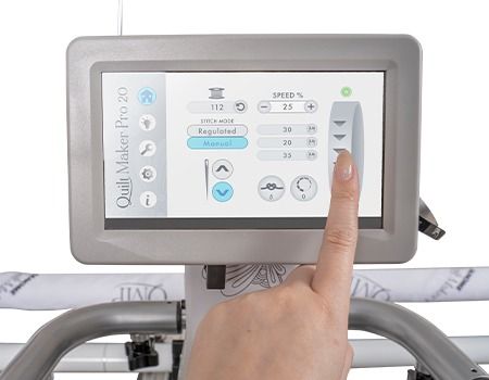 Person's finger touching a touchscreen on a quilting machine, adjusting the settings.