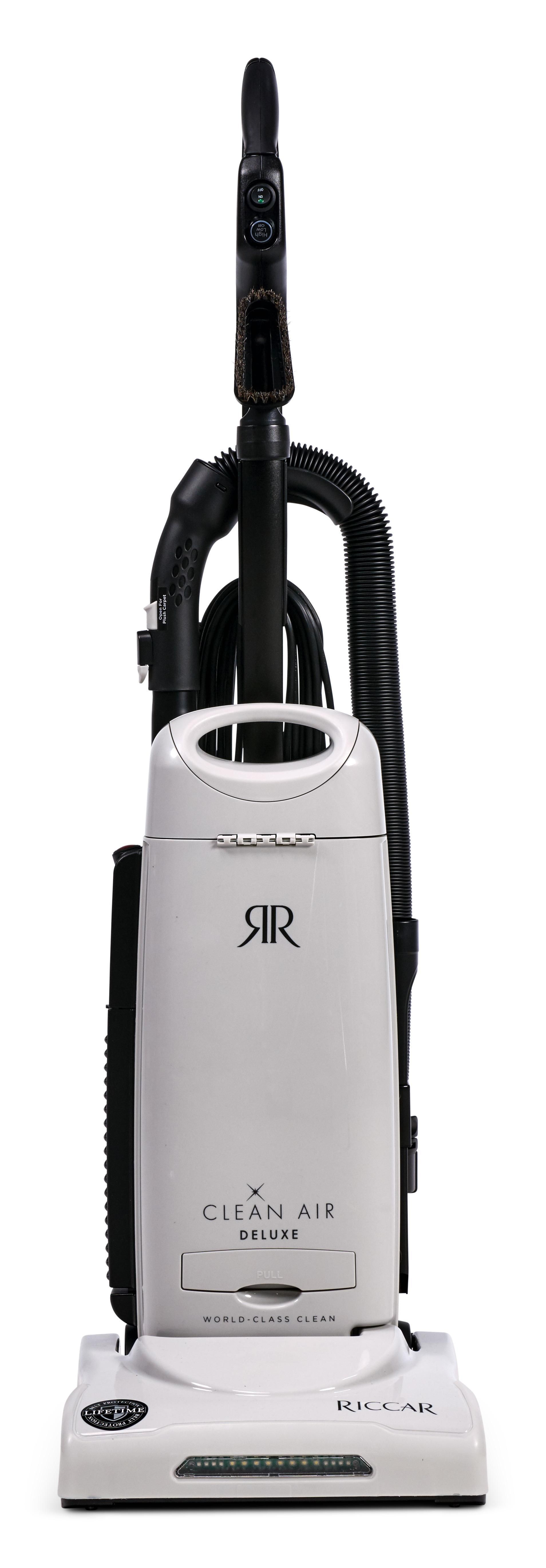 An upright vacuum cleaner in white and black, standing vertically on a plain background.