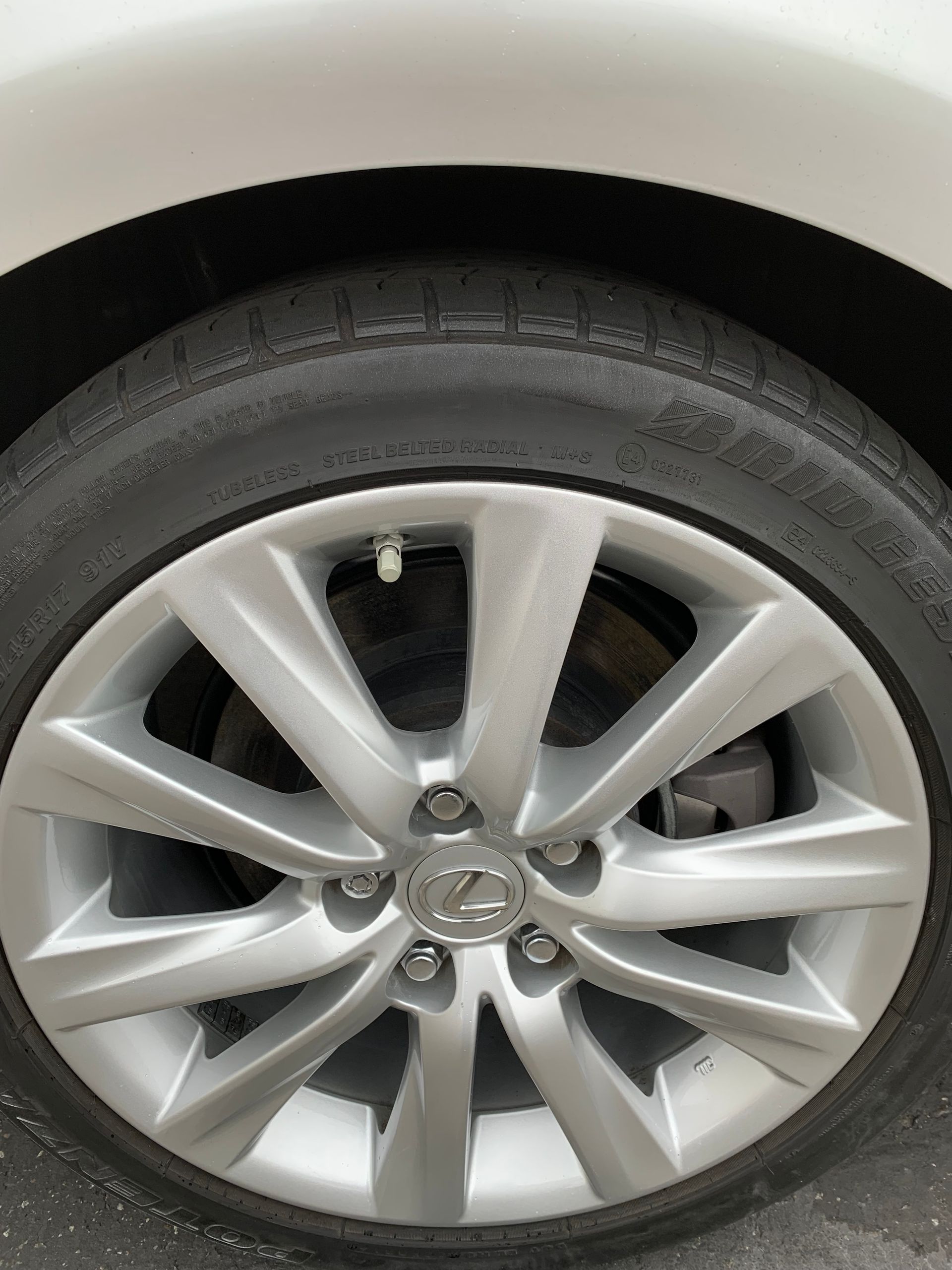 Close-up of a silver car wheel and tire with a Volkswagen logo on the hubcap.