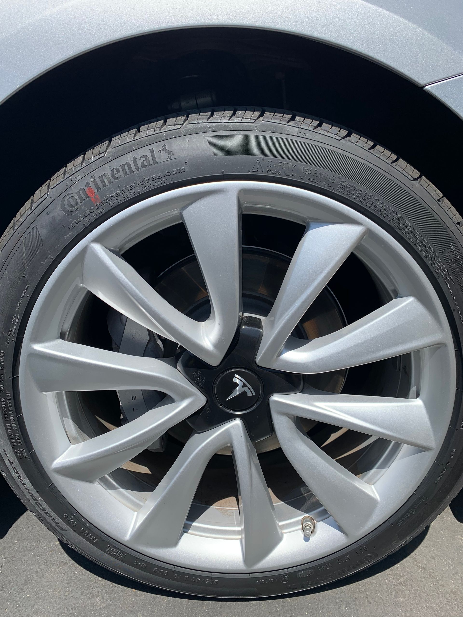 Close-up of a silver car wheel with a multi-spoke rim and black tire.