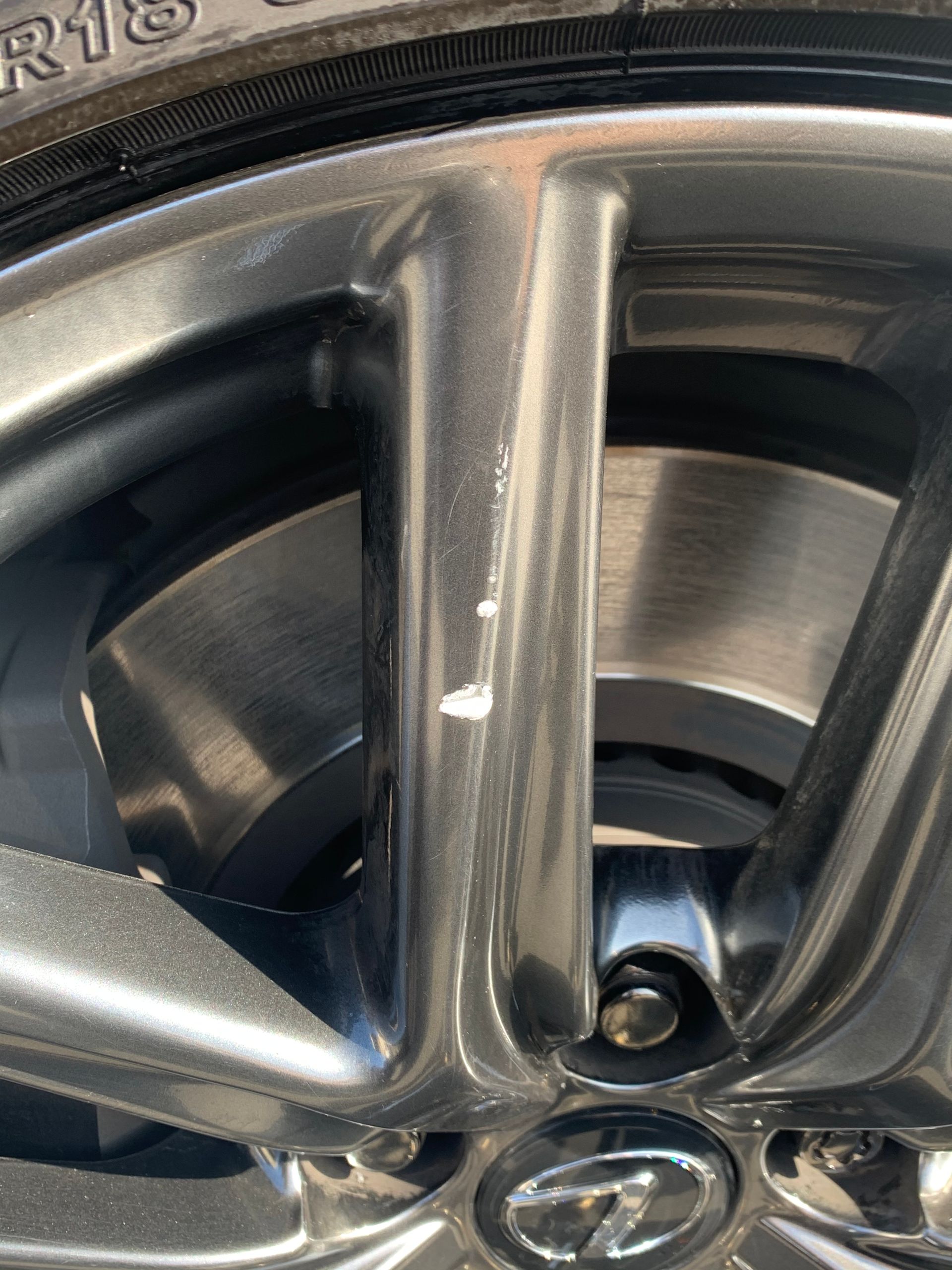 Close-up of a silver car wheel rim with Hyundai logo and visible tire tread.