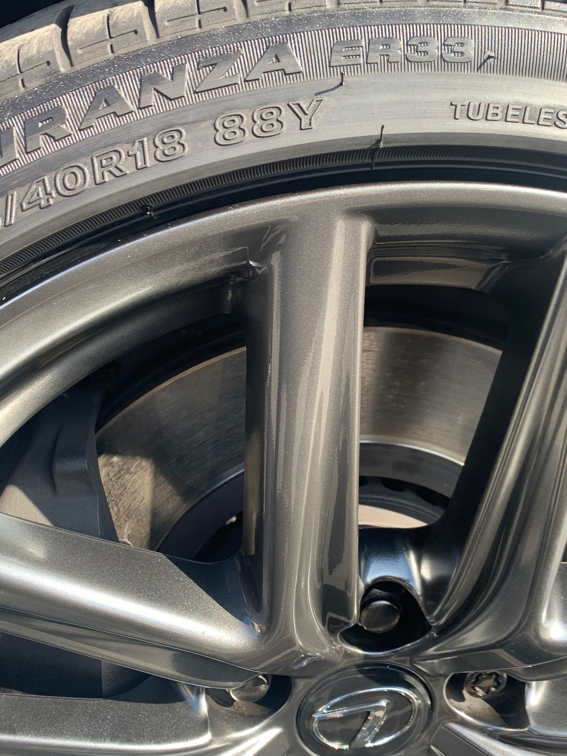 Close-up of a black alloy car wheel and tire with Subaru logo on the center cap.