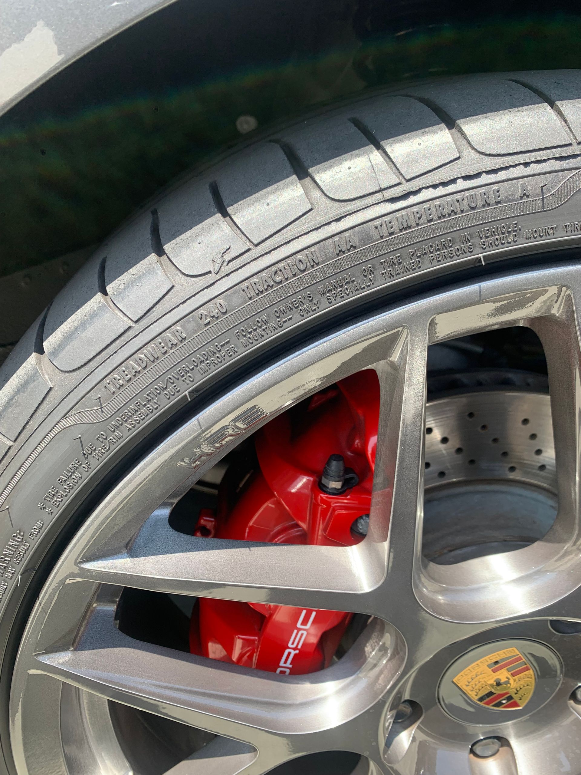 Close-up of a car wheel with a red brake caliper and silver rim.