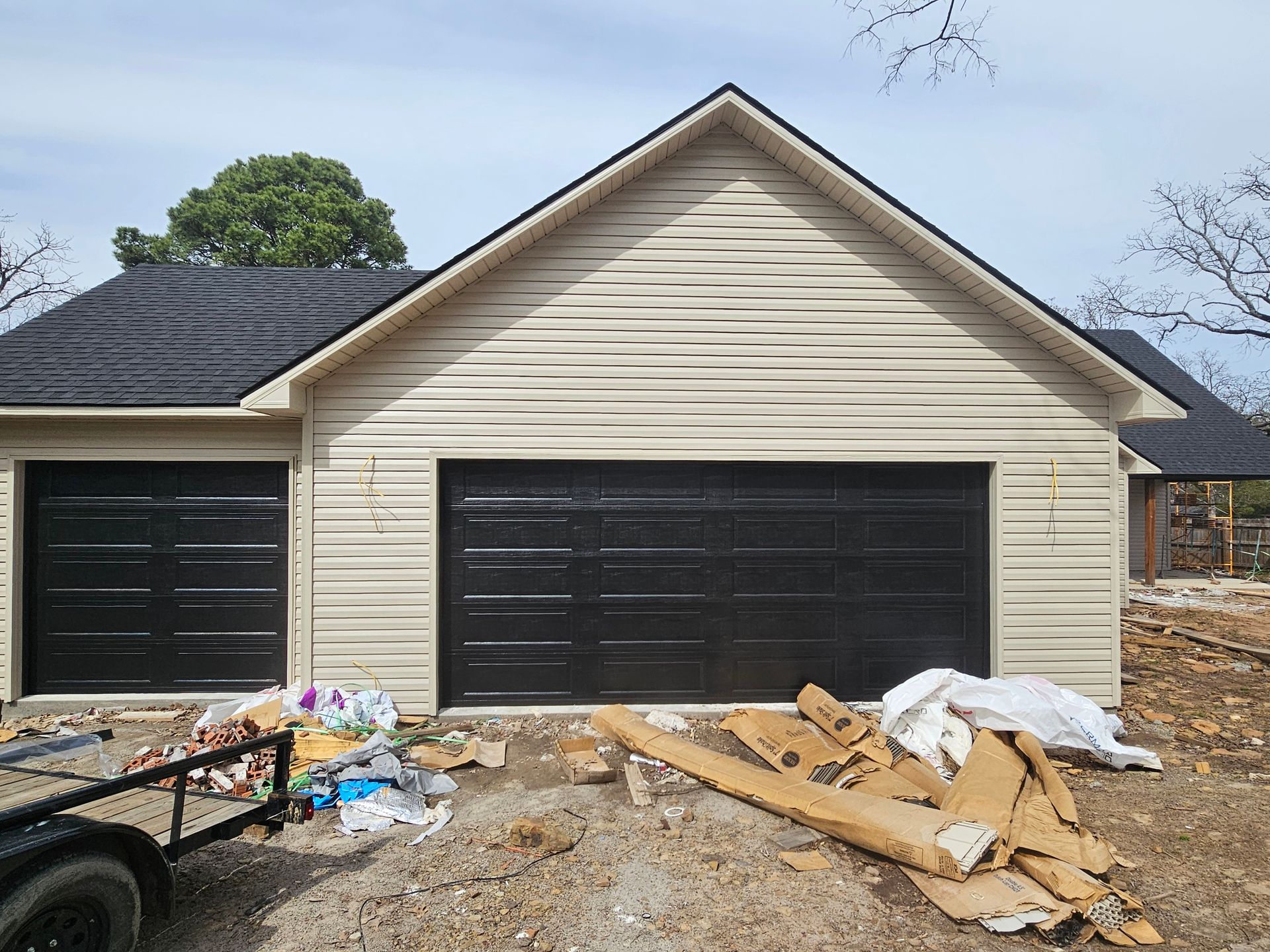 A house with a black garage door is being built