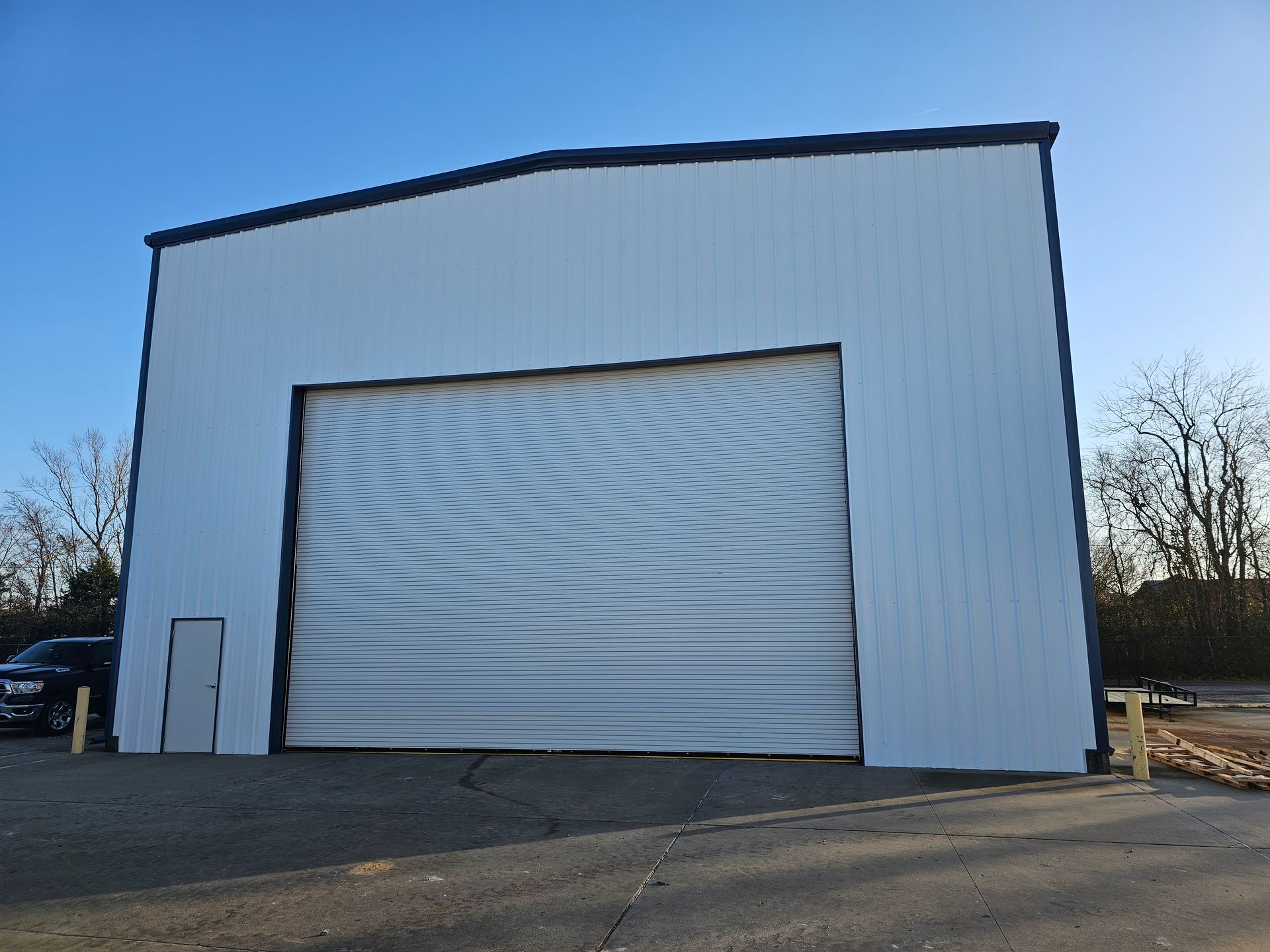 A large white building with a large garage door.