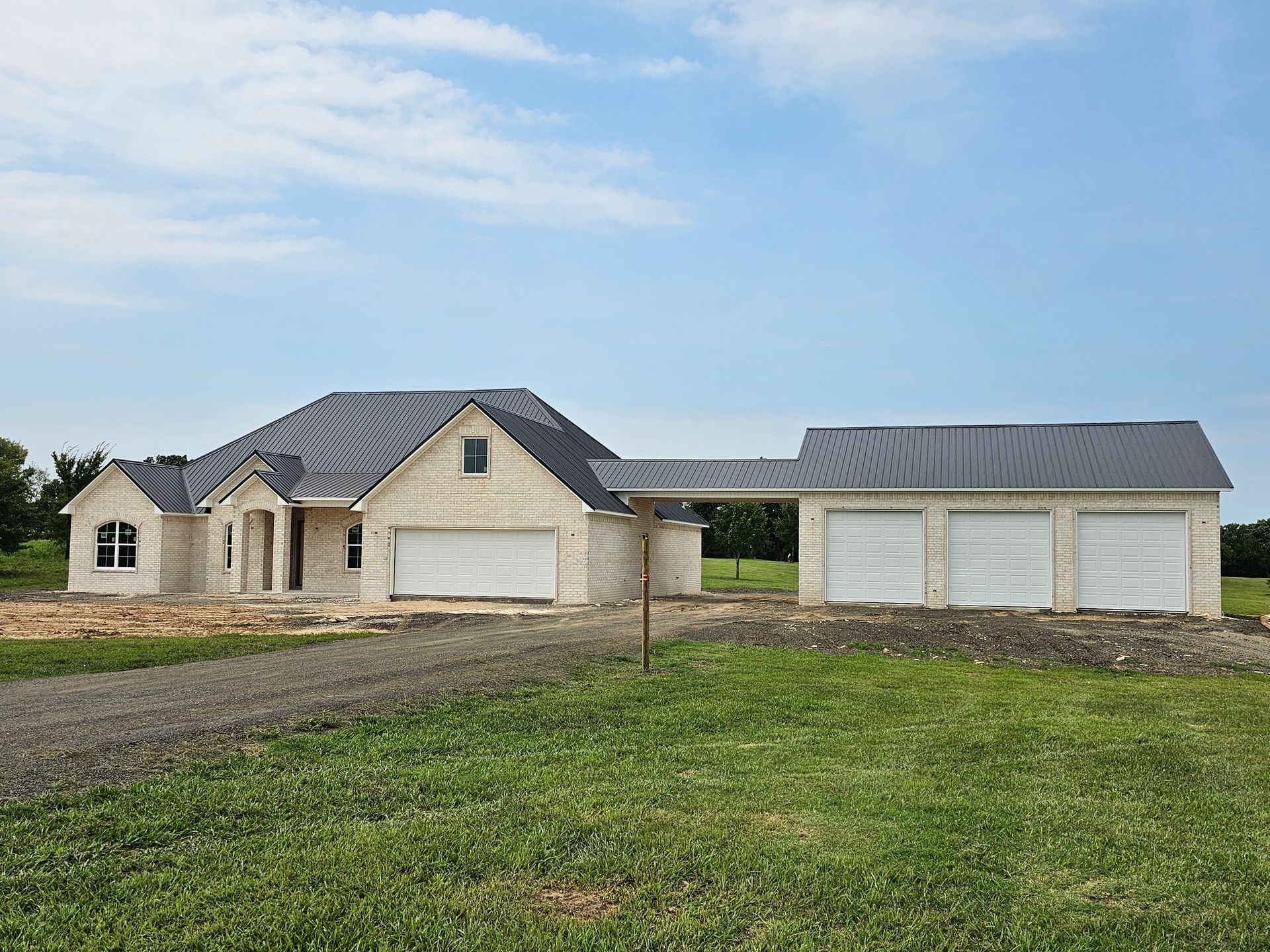 A large house is being built on a lush green field.