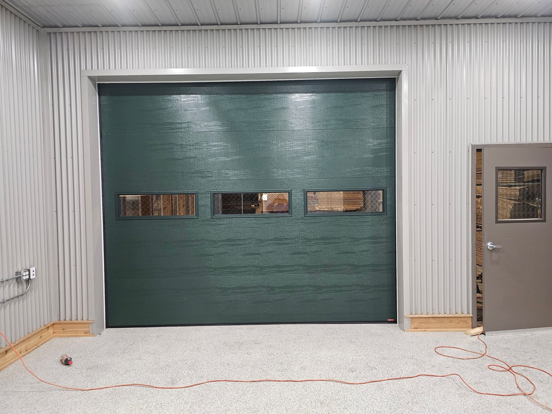 A garage with a green garage door and a door