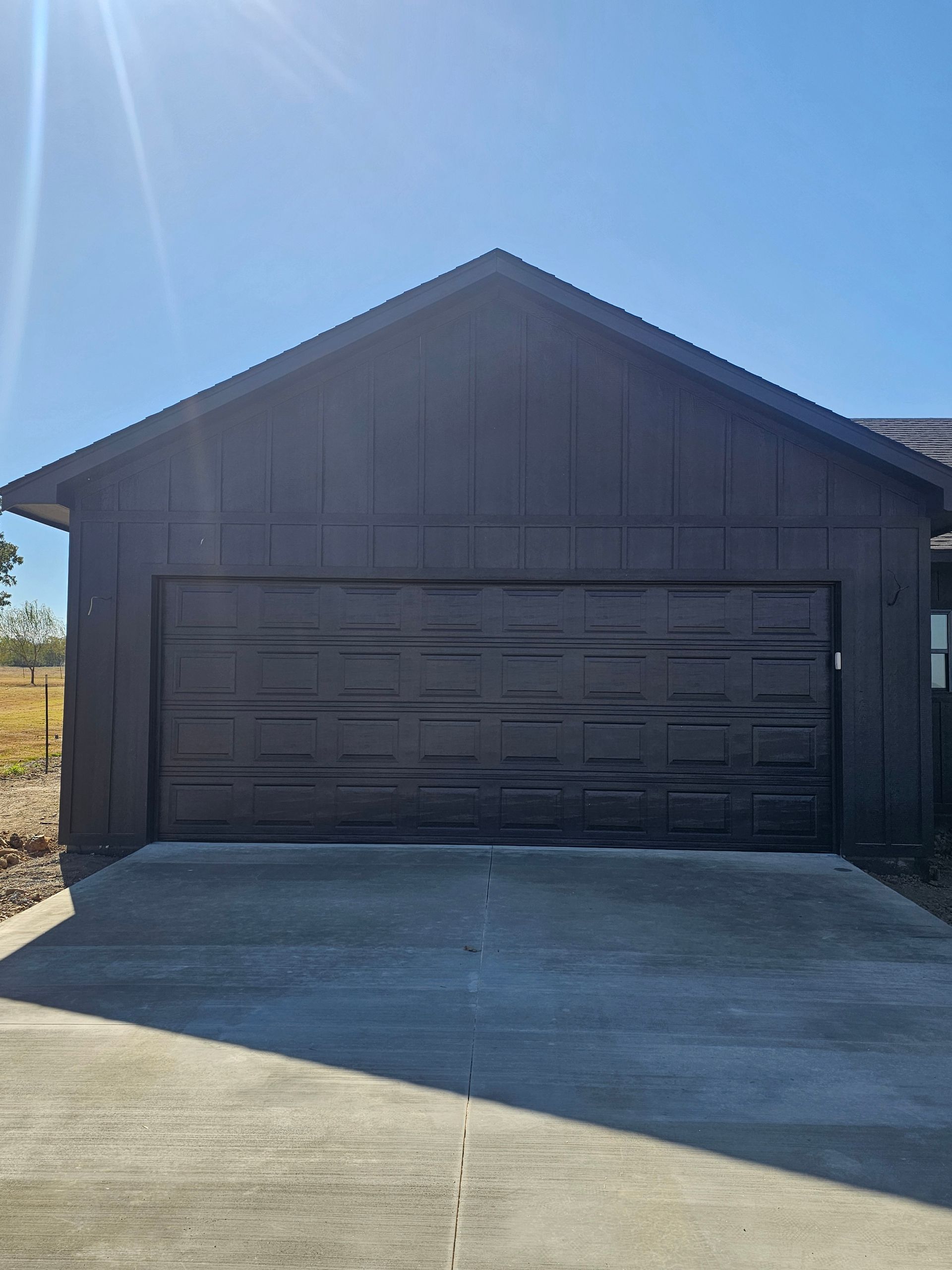 A large garage door is sitting in front of a house.